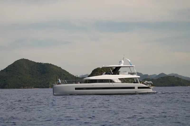 Sixty7 Yacht Photos Pics 2023 Lagoon SIXTY 7 yacht cruising near lush green islands.