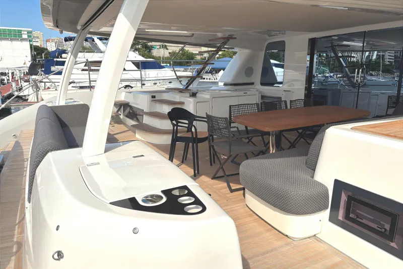 Sixty7 Yacht Photos Pics Luxurious 2023 Lagoon SIXTY 7 yacht deck with seating and dining area at marina.