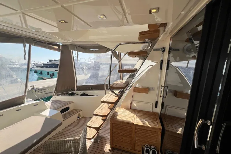  Yacht Photos Pics Interior of 2013 Prestige 620 yacht with wooden stairs and seating area.