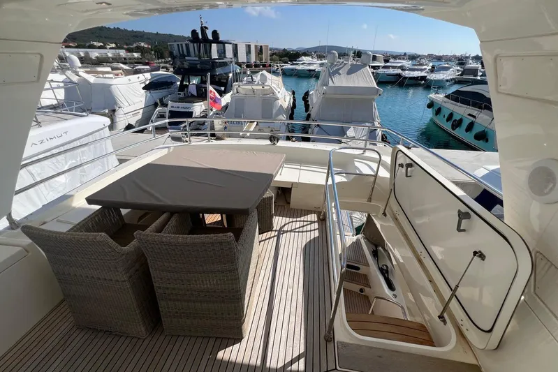  Yacht Photos Pics Luxurious 2013 Prestige 620 yacht deck with dining area, docked in a marina.