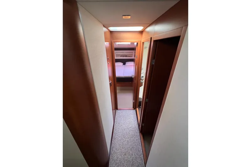  Yacht Photos Pics Narrow hallway inside 2013 Prestige 620 yacht, leading to a cozy bedroom.