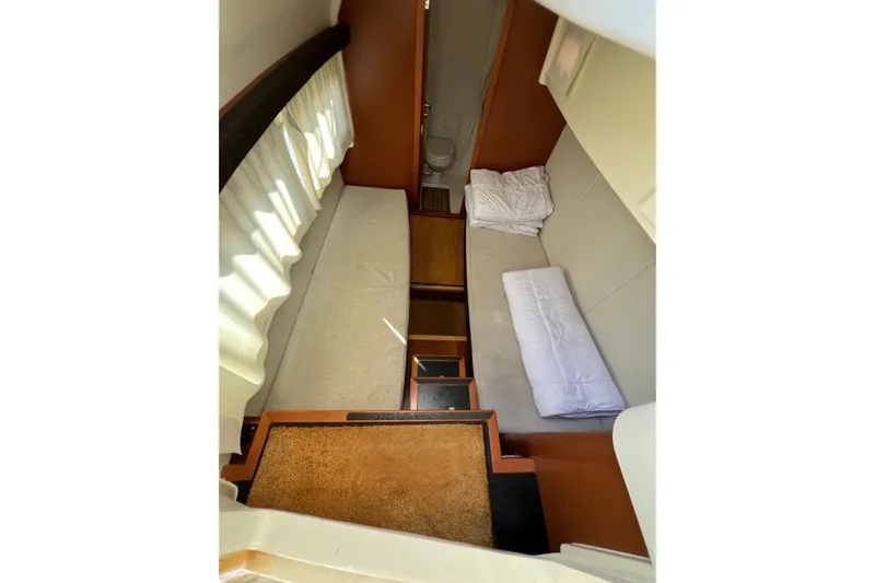  Yacht Photos Pics Interior cabin of a 2013 Prestige 620 yacht, featuring cozy beds and a small bathroom.
