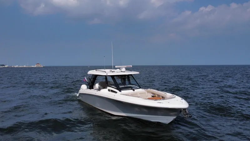  Yacht Photos Pics 2022 Boston Whaler 350 Realm boat cruising on open water under a cloudy sky.