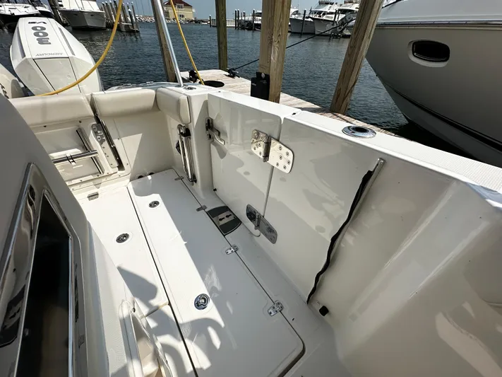  Yacht Photos Pics 2022 Boston Whaler 350 Realm boat interior, docked at marina with visible water and other boats.
