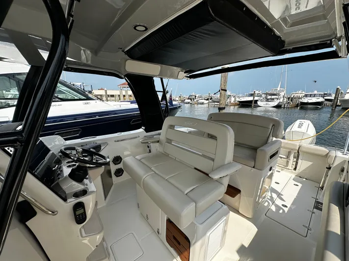  Yacht Photos Pics 2022 Boston Whaler 350 Realm interior with luxurious seating at a marina.