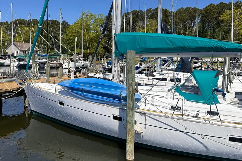  Yacht Photos Pics 2000 Beneteau 411 sailboat docked in a marina, featuring teal covers and a sleek design.