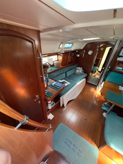  Yacht Photos Pics Interior of a 2000 Beneteau 411 sailboat with wooden finishes and teal seating.