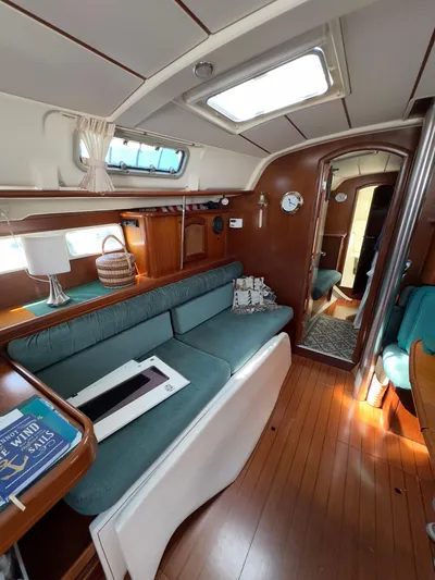 Yacht Photos Pics Interior of 2000 Beneteau 411 sailboat with wooden flooring and cozy seating area.