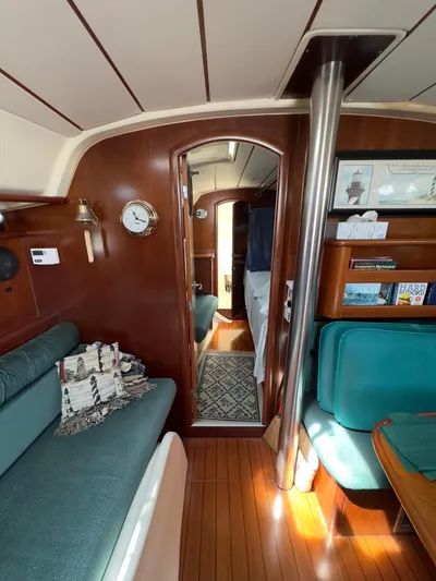  Yacht Photos Pics Interior of 2000 Beneteau 411 sailboat with wood paneling and teal seating.