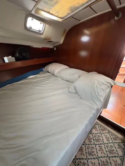  Yacht Photos Pics Cozy cabin interior of a 2000 Beneteau 411 sailboat with a neatly made bed.