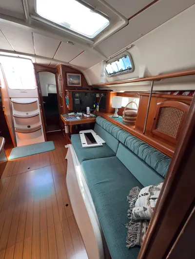  Yacht Photos Pics Interior of 2000 Beneteau 411 sailboat with teal seating and wooden accents.