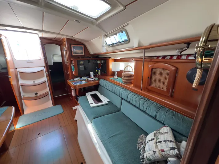  Yacht Photos Pics Interior of 2000 Beneteau 411 sailboat with teal seating and wooden accents.
