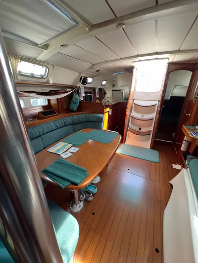  Yacht Photos Pics Interior of 2000 Beneteau 411 sailboat with wooden flooring and cozy seating area.