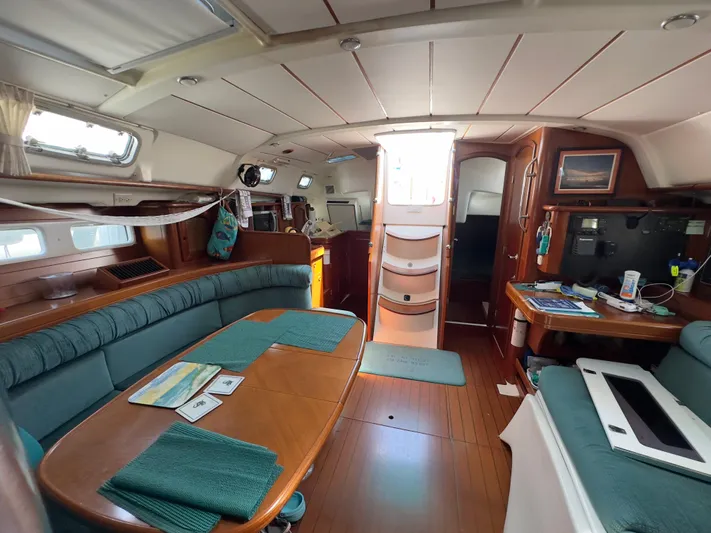  Yacht Photos Pics Interior of a 2000 Beneteau 411 sailboat, featuring a cozy dining area and navigation station.