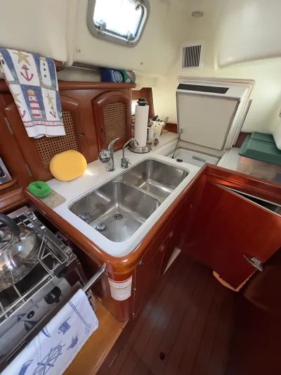  Yacht Photos Pics Beneteau 411 yacht kitchen with double sink, wooden cabinetry, and compact appliances, year 2000 model.