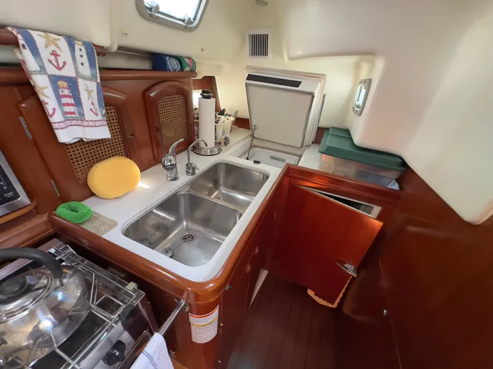  Yacht Photos Pics Interior of 2000 Beneteau 411 yacht kitchen with double sink and wooden cabinetry.