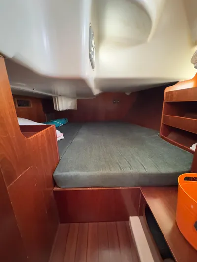  Yacht Photos Pics Cozy cabin interior of 2000 Beneteau 411 sailboat with wooden finish and comfortable bedding.