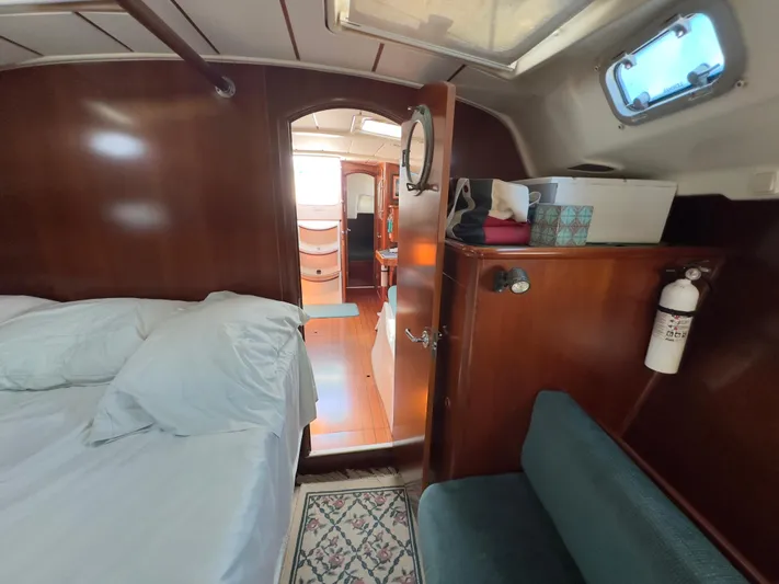  Yacht Photos Pics Cozy cabin interior of 2000 Beneteau 411 sailboat with wooden finish and comfortable bedding.