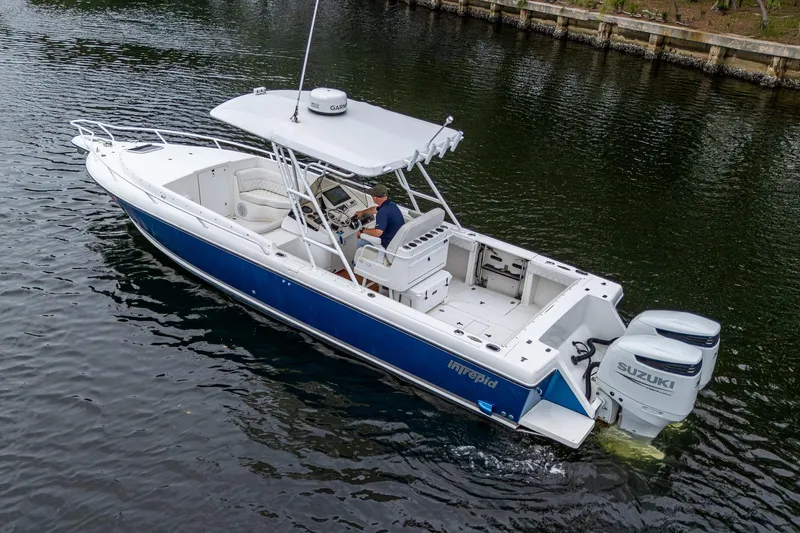  Yacht Photos Pics 2003 Intrepid 323 boat with Suzuki engines cruising on calm water.