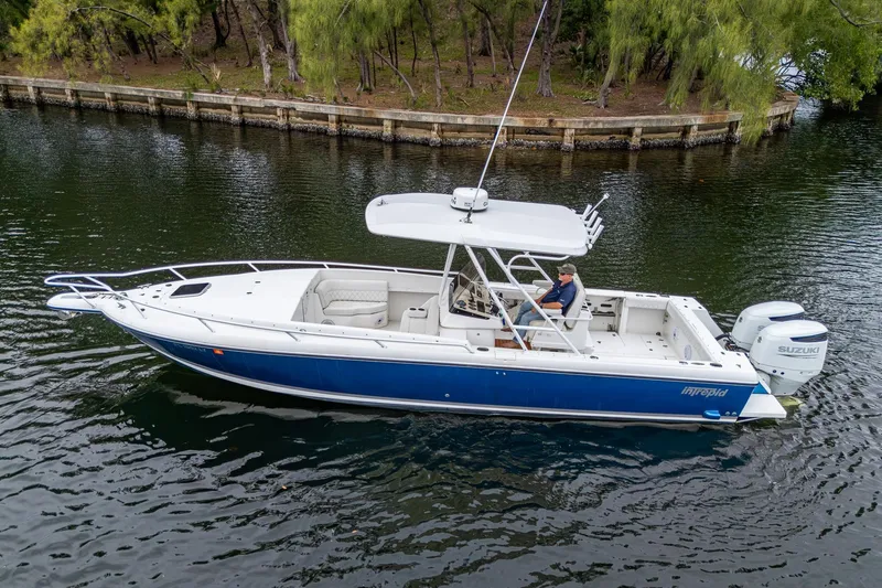  Yacht Photos Pics 2003 Intrepid 323 boat with Suzuki engines on a calm waterway.