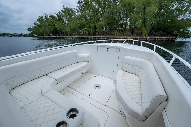  Yacht Photos Pics 2003 Intrepid 323 boat interior with white seating, cup holders, and scenic water view.
