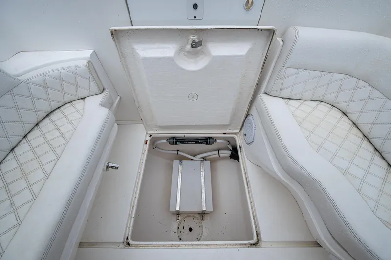  Yacht Photos Pics Open storage compartment on 2003 Intrepid 323 boat with white cushioned seating.