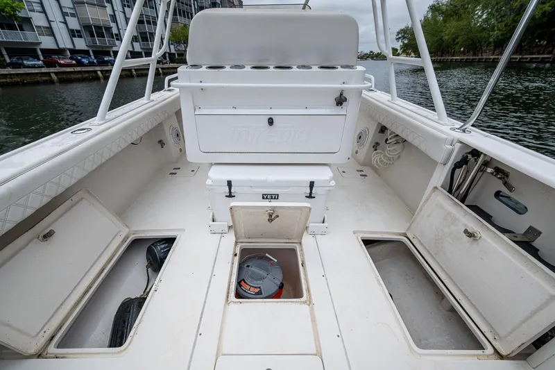  Yacht Photos Pics 2003 Intrepid 323 boat interior with storage compartments and seating, docked by the water.