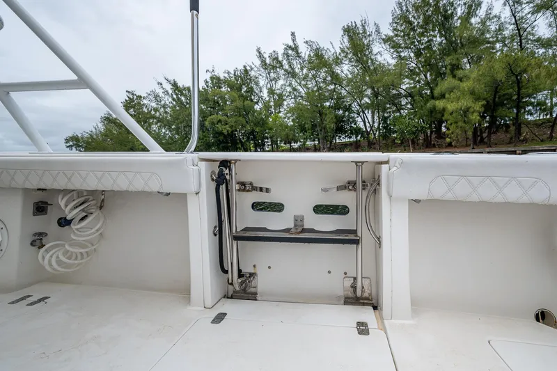  Yacht Photos Pics 2003 Intrepid 323 boat interior with white seating and storage, surrounded by trees.