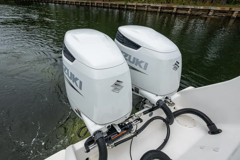  Yacht Photos Pics Twin Suzuki outboard motors on a 2003 Intrepid 323 boat, docked on calm water.