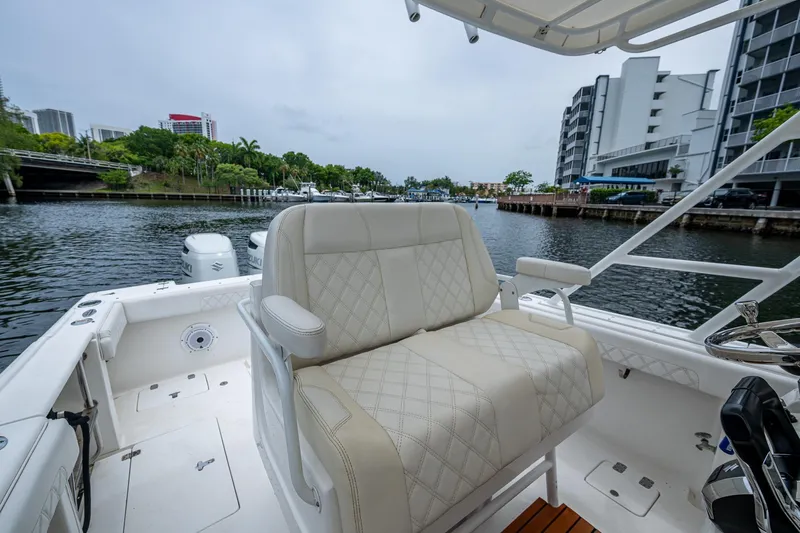 Yacht Photos Pics 2003 Intrepid 323 boat interior with plush seating, docked near waterfront buildings.