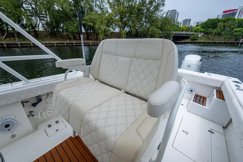 Yacht Photos Pics Luxurious seating on 2003 Intrepid 323 boat, featuring diamond-stitched upholstery and scenic waterway backdrop.