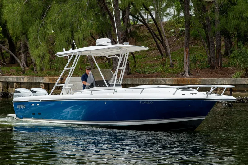  Yacht Photos Pics 2003 Intrepid 323 boat cruising on a calm waterway, surrounded by lush greenery.