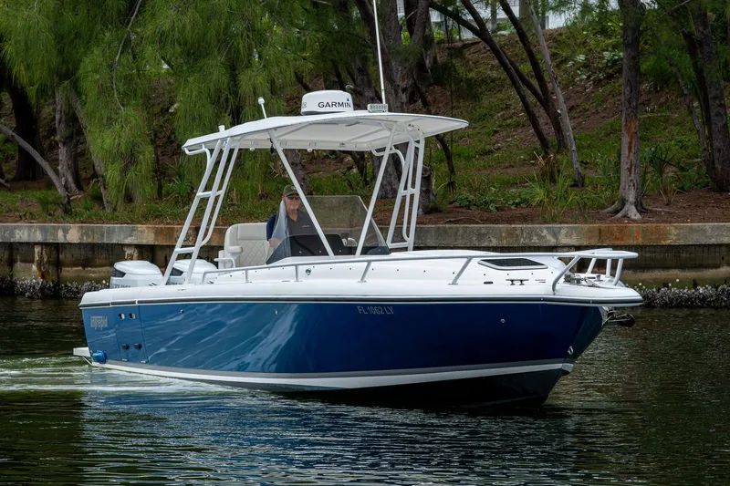  Yacht Photos Pics 2003 Intrepid 323 boat cruising on a calm waterway, surrounded by lush greenery.