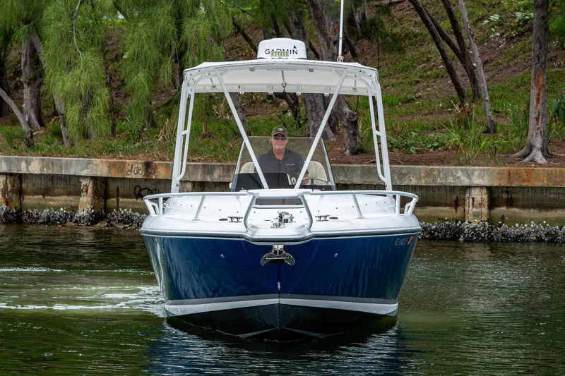  Yacht Photos Pics 2003 Intrepid 323 boat cruising near a wooded shoreline.