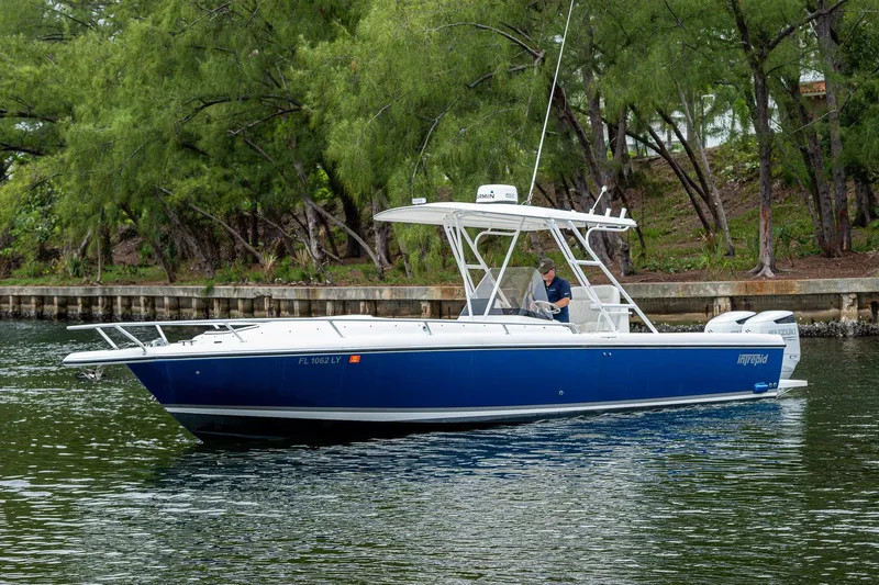  Yacht Photos Pics 2003 Intrepid 323 boat cruising on a calm waterway, surrounded by lush greenery.
