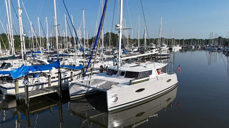 Sirena Yacht Photos Pics 2015 Fountaine Pajot Helia 44 catamaran docked in a marina with sailboats.