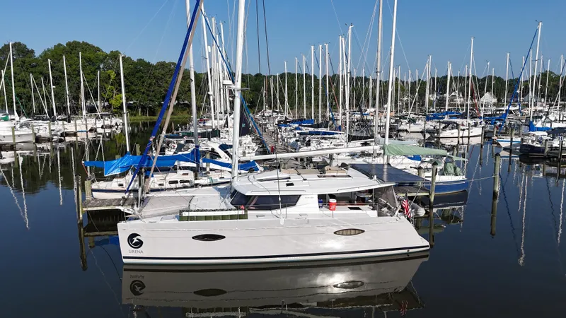 Sirena Yacht Photos Pics 2015 Fountaine Pajot Helia 44 catamaran docked in a marina, surrounded by sailboats.