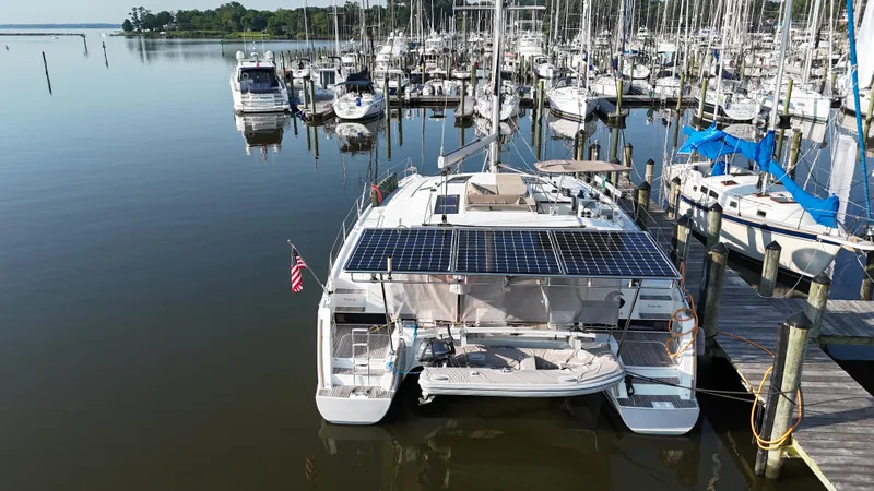 Sirena Yacht Photos Pics 2015 Fountaine Pajot Helia 44 catamaran docked, featuring solar panels and an American flag.