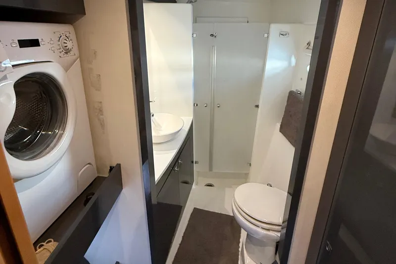 Sirena Yacht Photos Pics Bathroom interior of 2015 Fountaine Pajot Helia 44 with washer, sink, and toilet.