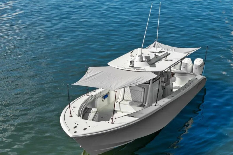  Yacht Photos Pics 2023 Yellowfin 39 Offshore boat on calm blue water, featuring a sunshade canopy.