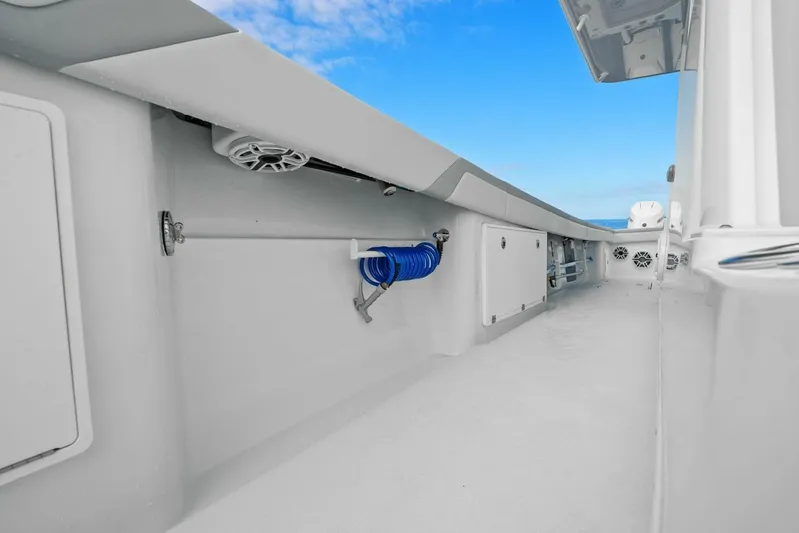  Yacht Photos Pics 2023 Yellowfin 39 Offshore boat deck with storage compartments and blue hose.