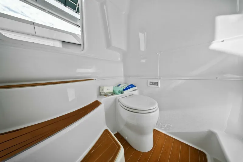  Yacht Photos Pics 2023 Yellowfin 39 Offshore boat bathroom with modern toilet and wooden flooring.