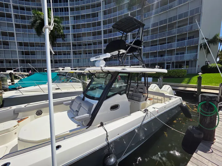 Grey Hawk Yacht Photos Pics 2023 Boston Whaler 360 Outrage docked near modern building.