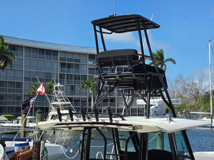 Grey Hawk Yacht Photos Pics 2023 Boston Whaler 360 Outrage with tower, docked near waterfront buildings and palm trees.