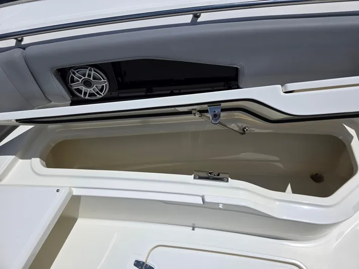 Grey Hawk Yacht Photos Pics Open storage compartment on 2023 Boston Whaler 360 Outrage boat, featuring sleek design and speaker.