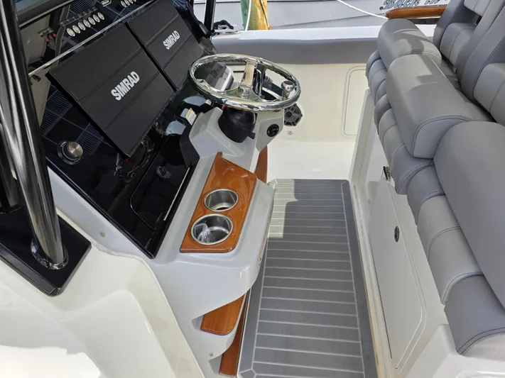 Grey Hawk Yacht Photos Pics 2023 Boston Whaler 360 Outrage helm with Simrad displays and cushioned seating.