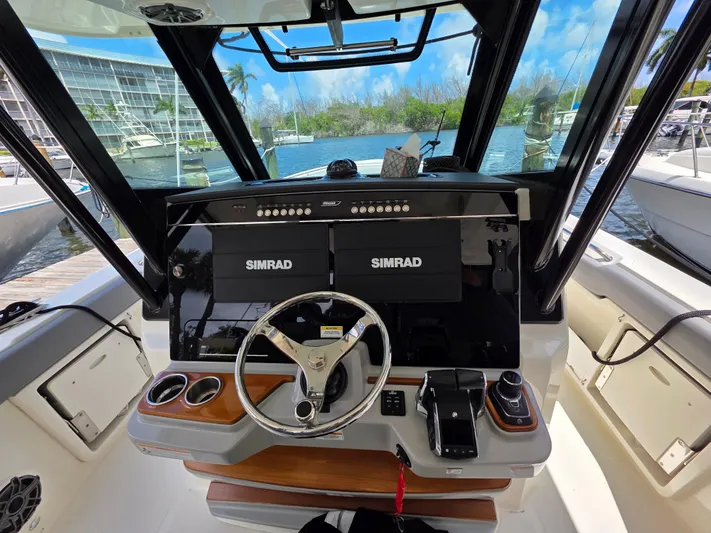 Grey Hawk Yacht Photos Pics 2023 Boston Whaler 360 Outrage helm with Simrad displays and modern controls.
