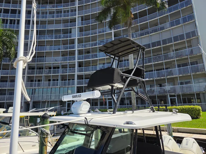 Grey Hawk Yacht Photos Pics 2023 Boston Whaler 360 Outrage boat docked near a modern building.