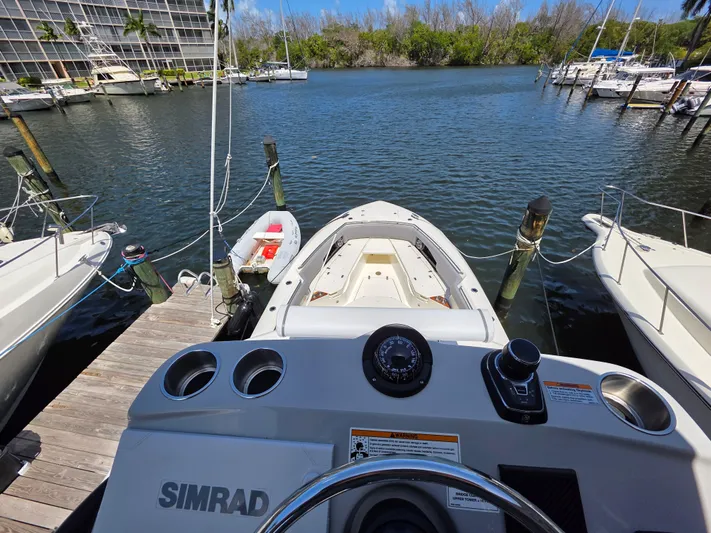 Grey Hawk Yacht Photos Pics Boston Whaler 360 Outrage 2023 at dock, view from helm, surrounded by water and boats.