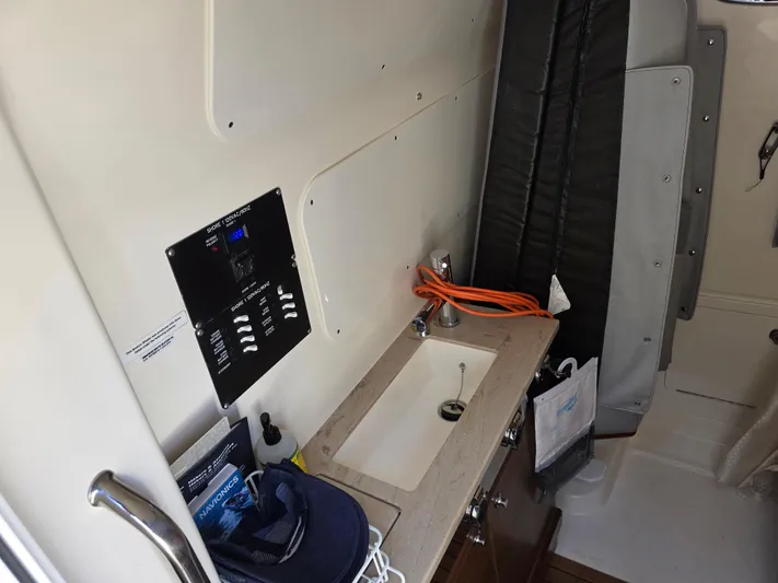 Grey Hawk Yacht Photos Pics 2023 Boston Whaler 360 Outrage cabin interior with sink and control panel.